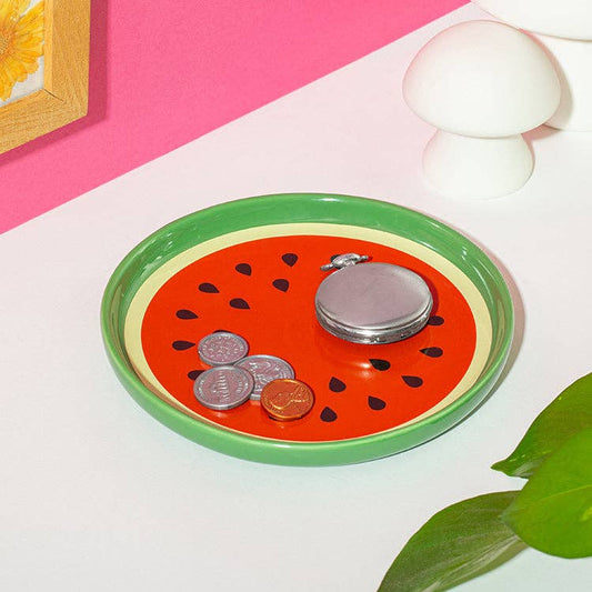 Mellow Monkey porcelain watermelon trinket tray with red center and green rind, holding coins and a pocket watch.