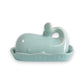 Mellow Monkey aqua ceramic whale butter dish with lid, featuring a tail handle and wave pattern on the base.