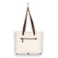 Mellow Monkey white canvas and leather crossbody tote bag with a back zipper pocket hanging on a hook.