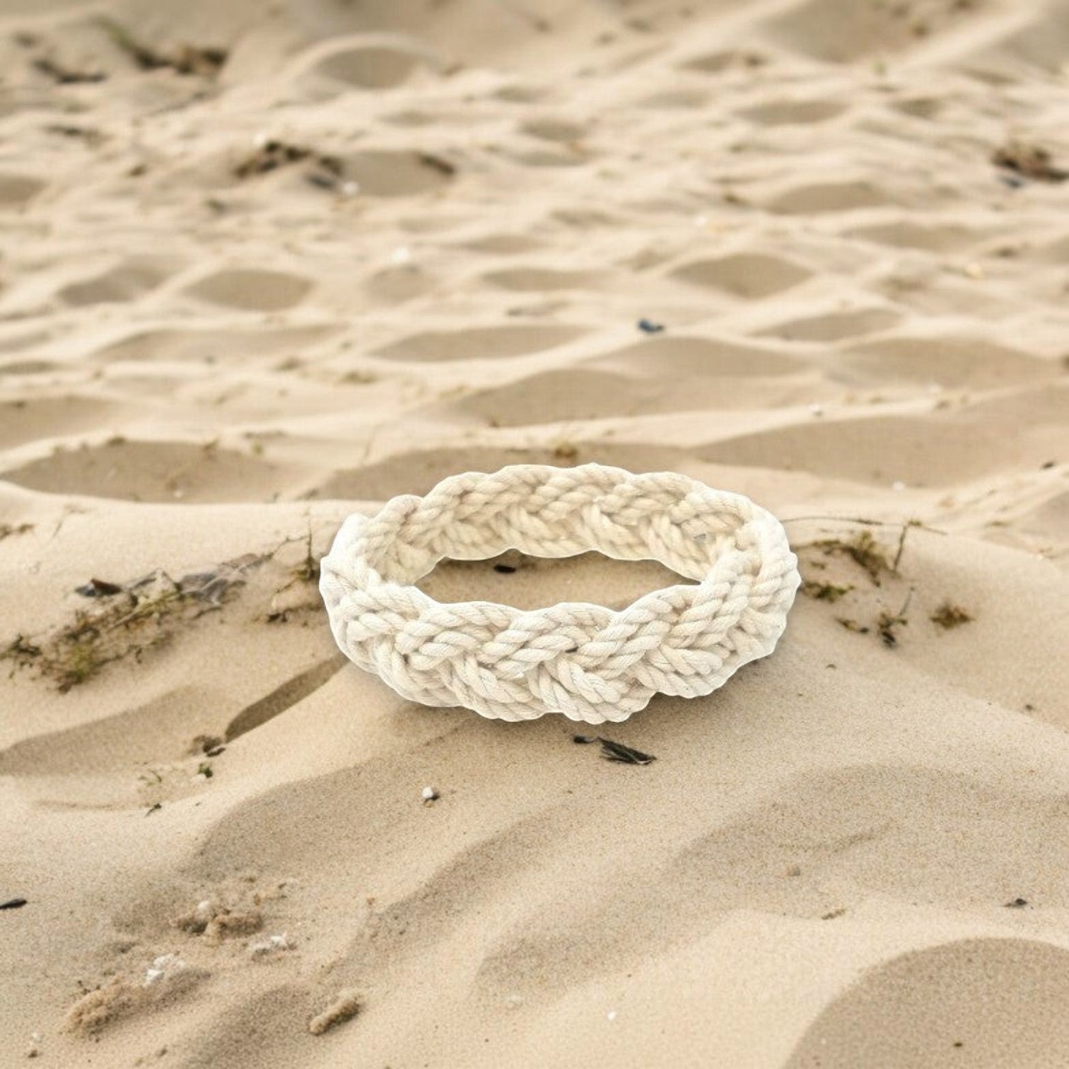 Mellow Monkey white cotton cord sailor knot bracelet resting on sandy beach