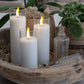 Mellow Monkey set of three white flameless LED glass candles with a warm flickering glow in a rustic wooden bowl.