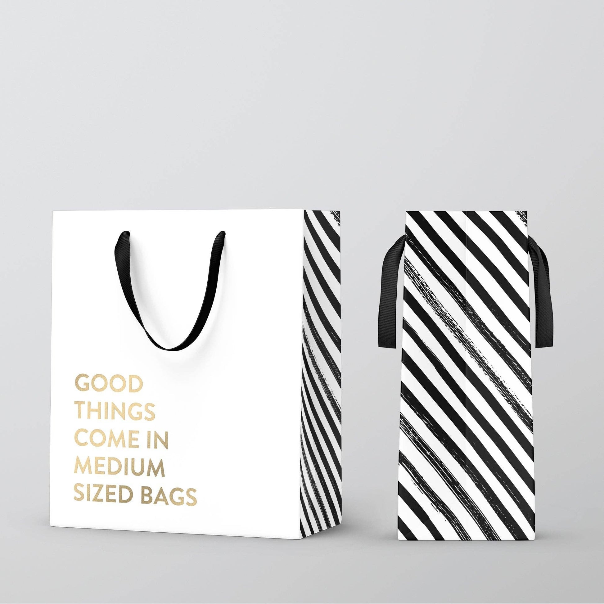 Mellow Monkey white kraft paper gift bag with gold foil text and black nylon handles, side view with striped pattern.