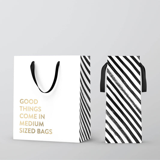 Mellow Monkey white kraft paper gift bag with gold foil text and black nylon handles, side view with striped pattern.