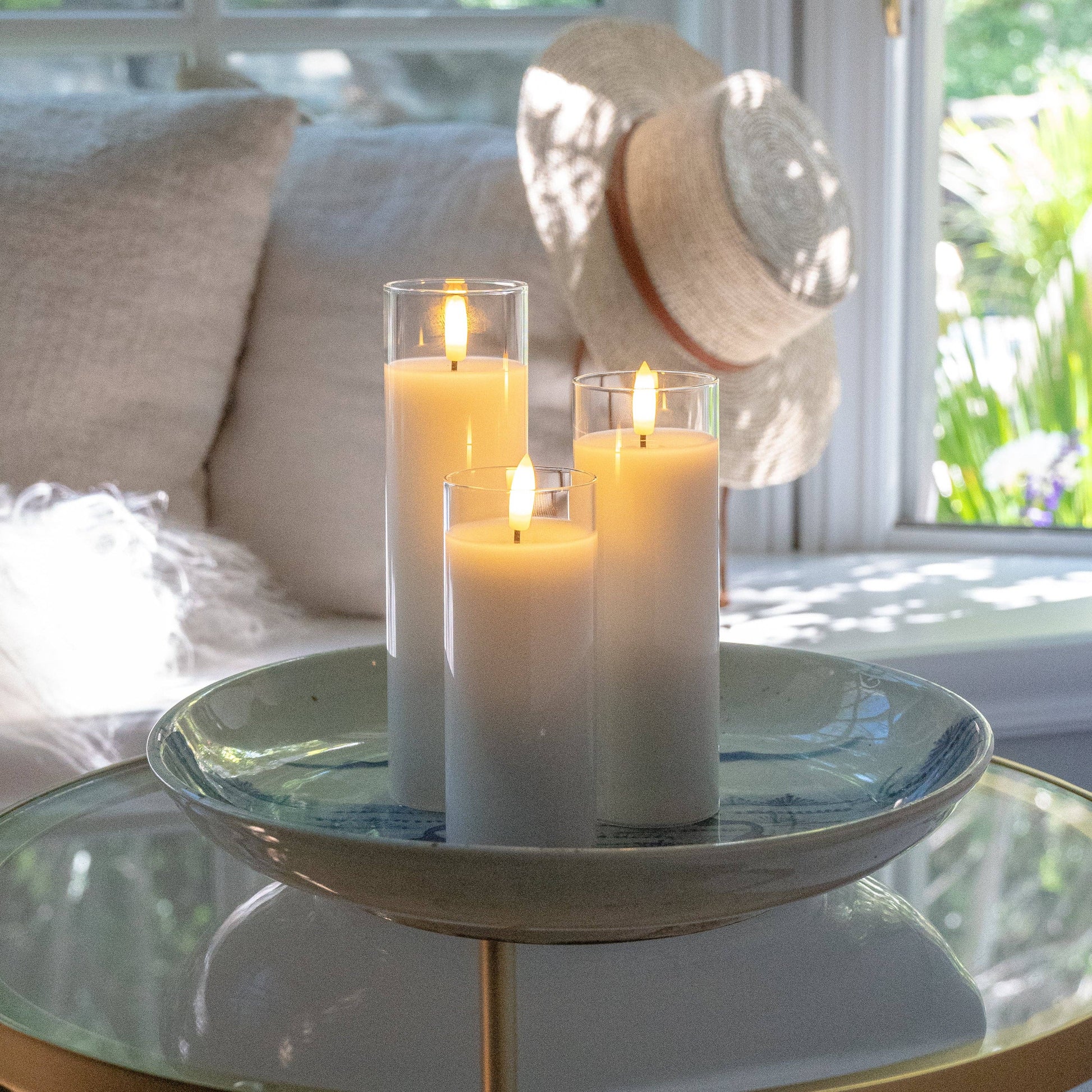 Mellow Monkey set of three white flameless LED pillar candles in glass holders on a decorative bowl