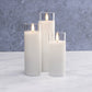 Mellow Monkey set of three white flameless LED pillar candles in glass holders with a warm flickering glow.