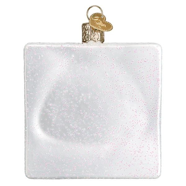 Mellow Monkey white square blown glass ornament with pink glitter accents and gold heart charm.