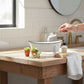 Mellow Monkey white iron bathtub soap dish with black trim, featuring clawfoot design and drainage holes.