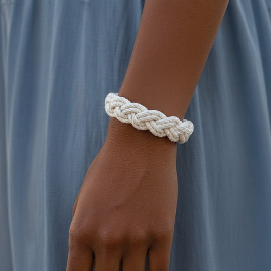 Mellow Monkey white cotton cord sailor knot bracelet worn on a wrist against a blue dress background