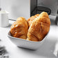 Mellow Monkey Olivia white stoneware bowl with embossed weave design, holding croissants. Dishwasher and microwave safe.