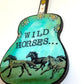 Mellow Monkey hand-painted guitar ornament featuring Wild Horses artwork and floral details on a teal background.