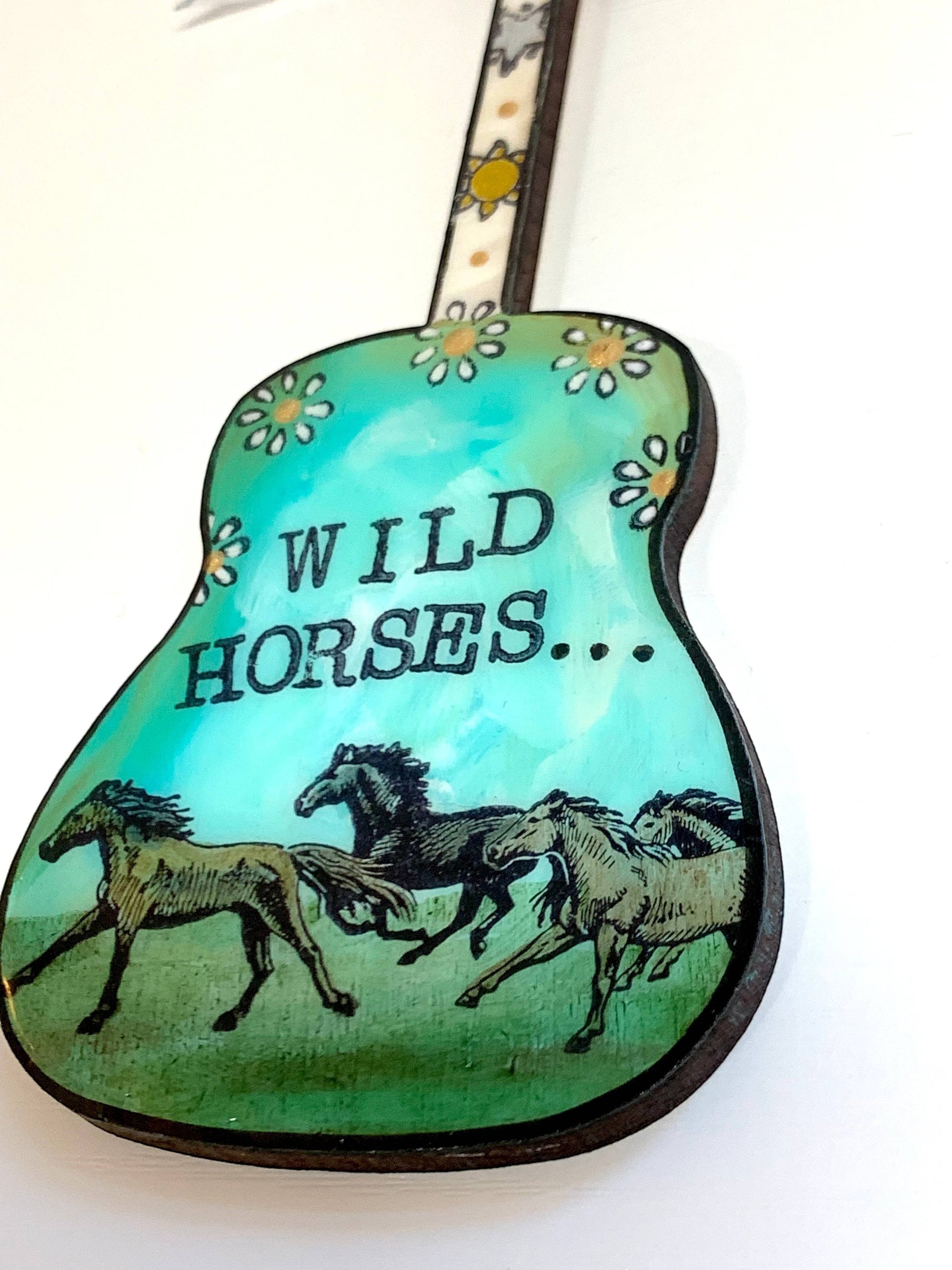 Mellow Monkey hand-painted guitar ornament featuring Wild Horses artwork and floral details on a teal background.