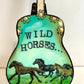 Mellow Monkey hand-painted guitar ornament featuring Wild Horses artwork in teal and green with floral accents.