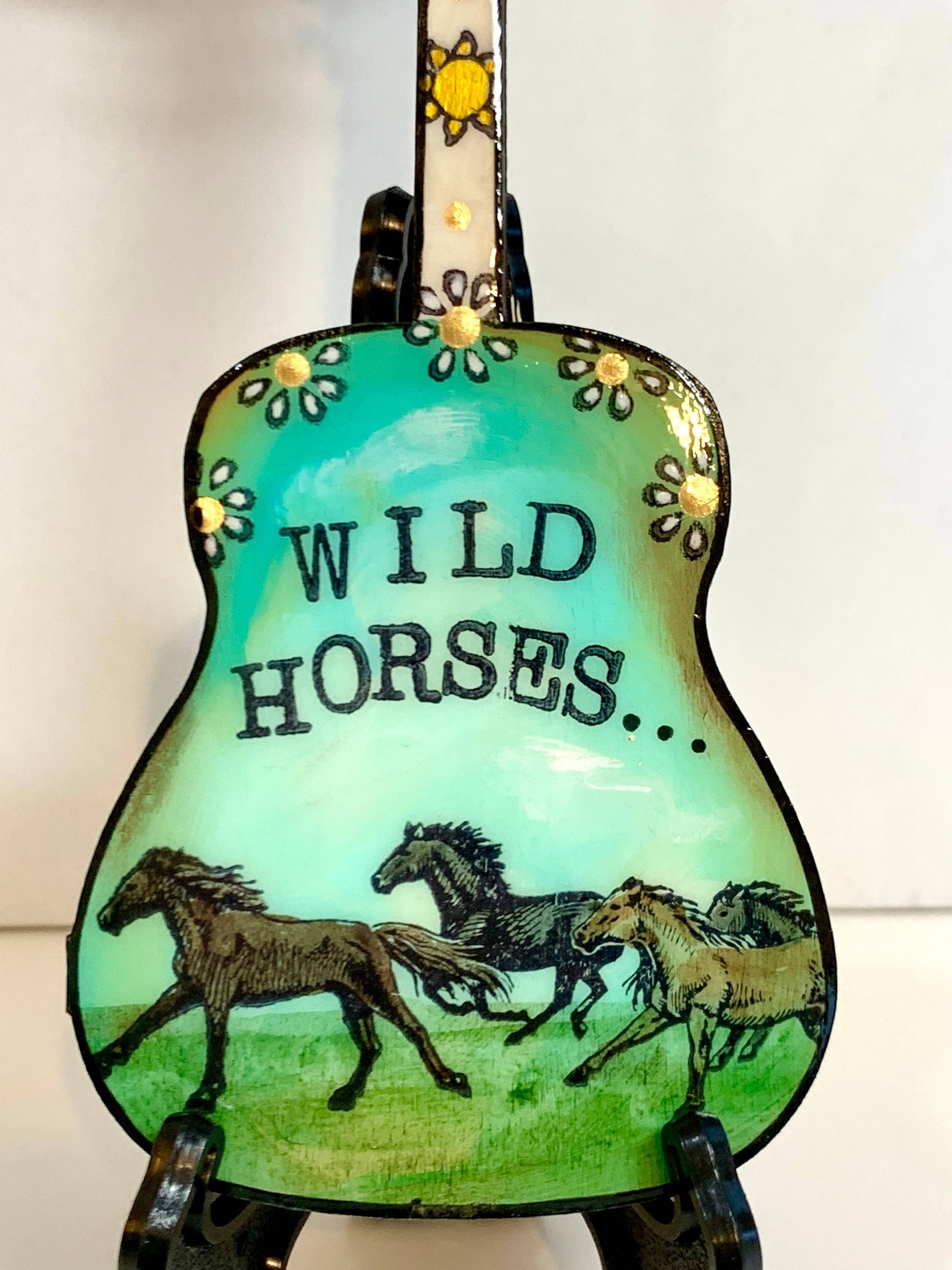 Mellow Monkey hand-painted guitar ornament featuring Wild Horses artwork in teal and green with floral accents.
