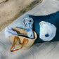 Mellow Monkey Ebb and Flow wine tote in blue and white abstract art, made of neoprene, holding a bottle.