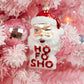 Mellow Monkey glass winking Santa ornament with glitter and red Ho Fo Sho lettering hanging on a pink Christmas tree.