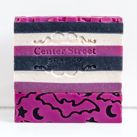 Mellow Monkey Witching Hour artisan soap bar with purple, black, and white stripes and bat and moon cutouts.