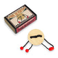 Mellow Monkey wooden brainteaser puzzle featuring a round disc with black string and red beads on a white background