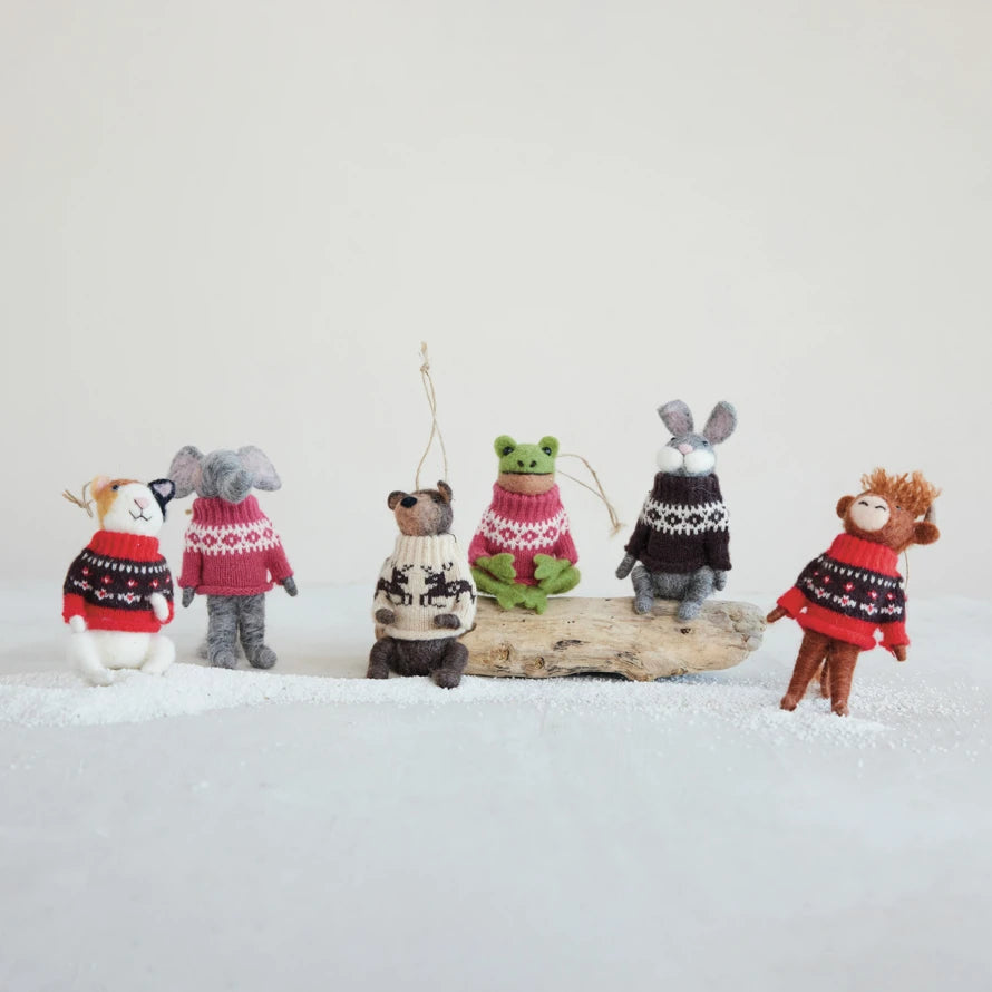 Mellow Monkey handcrafted wool felt animal ornaments wearing festive patterned sweaters on a snowy display