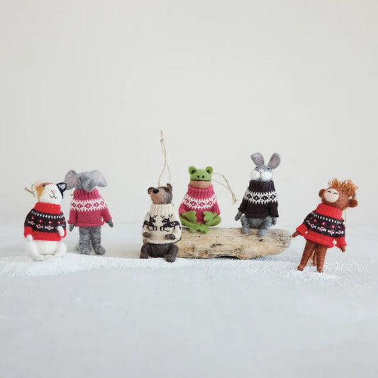 Mellow Monkey handcrafted wool felt animal ornaments wearing festive patterned sweaters on a snowy display
