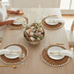 Mellow Monkey woven round placemat with a spiral design and a white clam rose shell edge, 13-inch diameter.