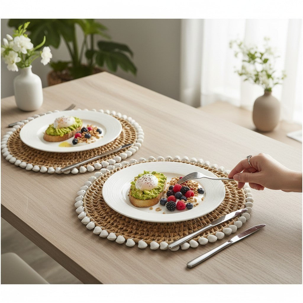 Mellow Monkey woven round placemat with natural straw and white clam rose shell edge, 13-inch diameter.